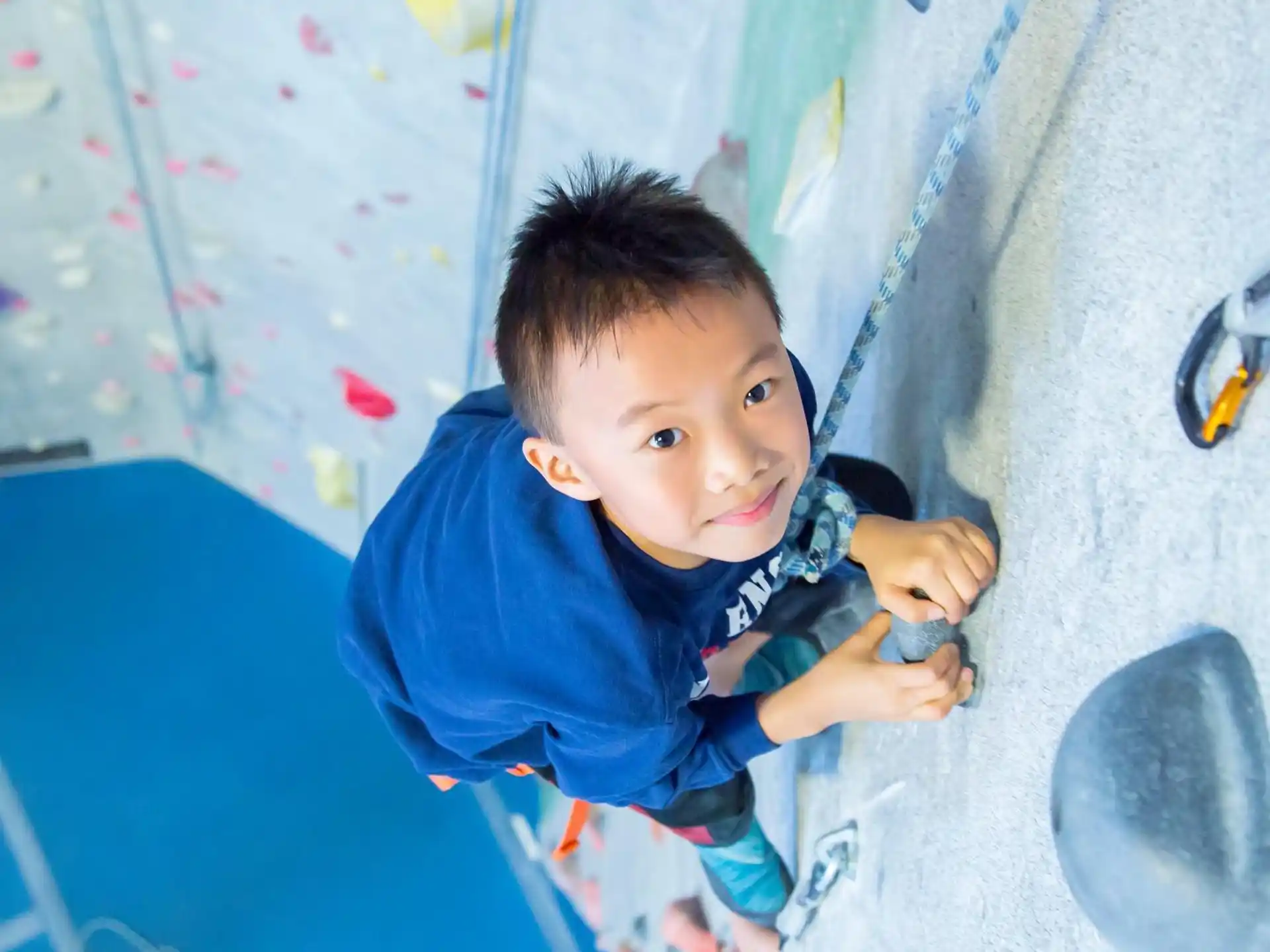 a boy climbing a climbing wall