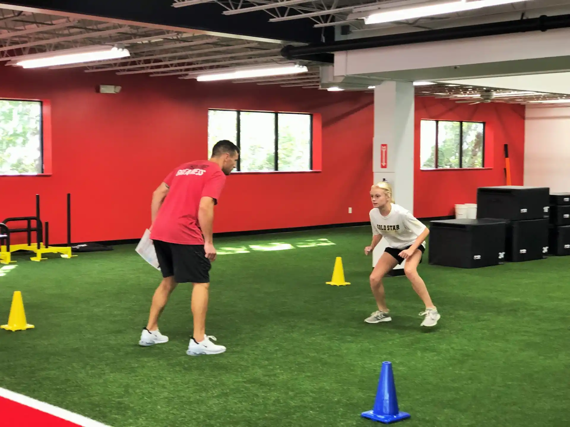 a couple of people playing frisbee in a gym