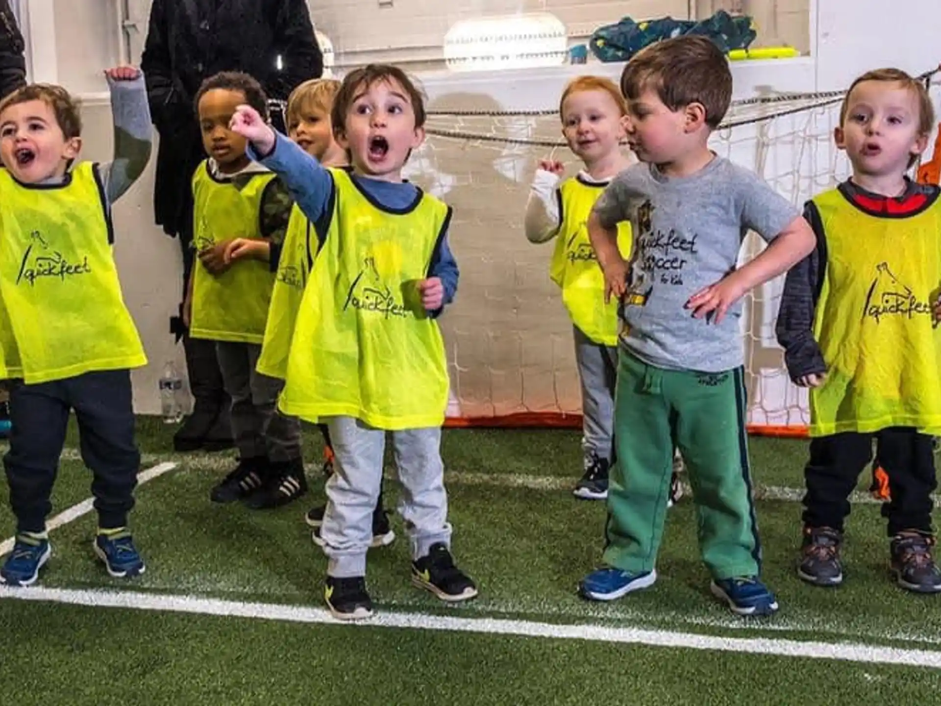 a group of children in matching green shirts on a green field