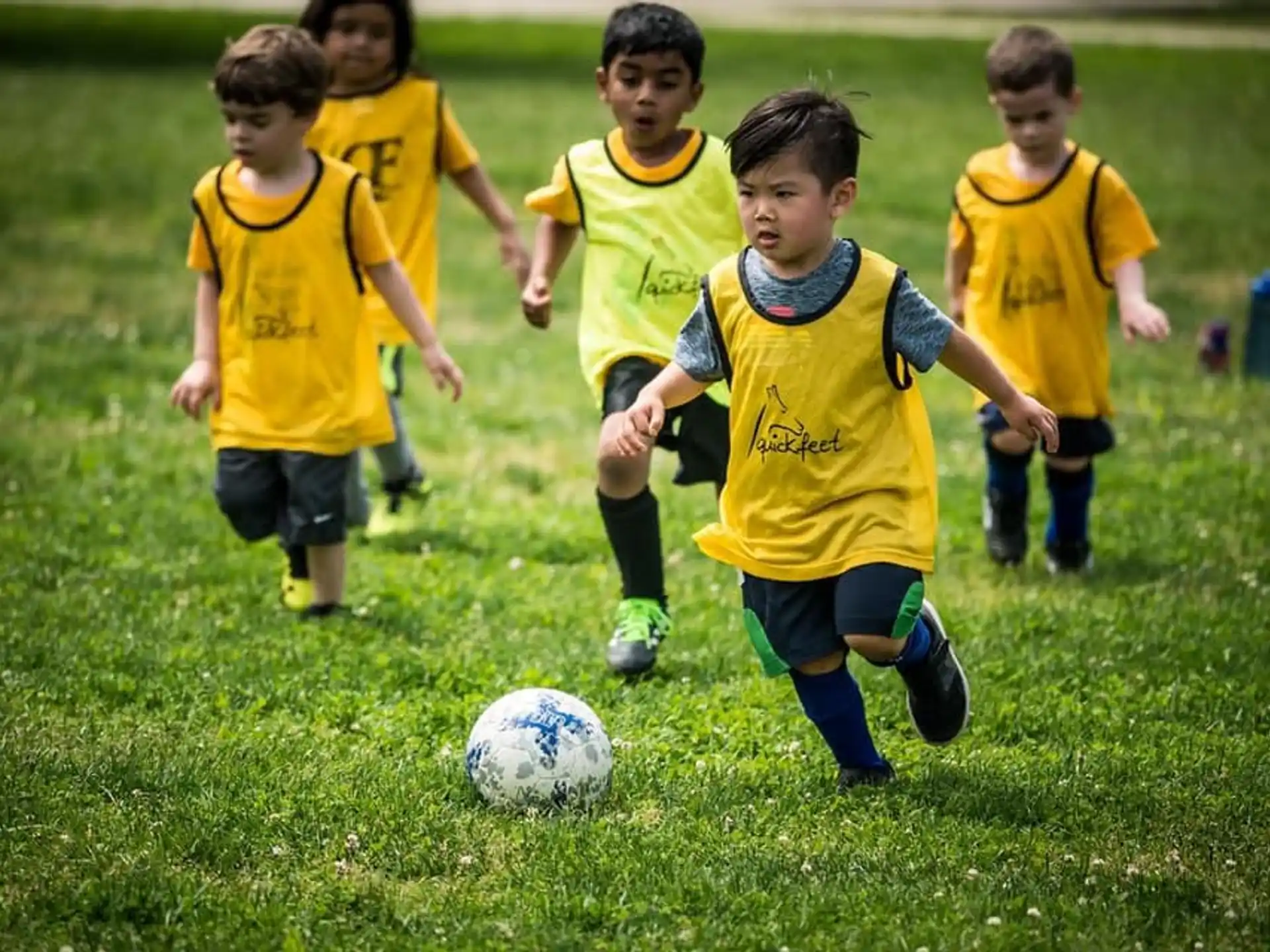 a group of kids compete over a football ball