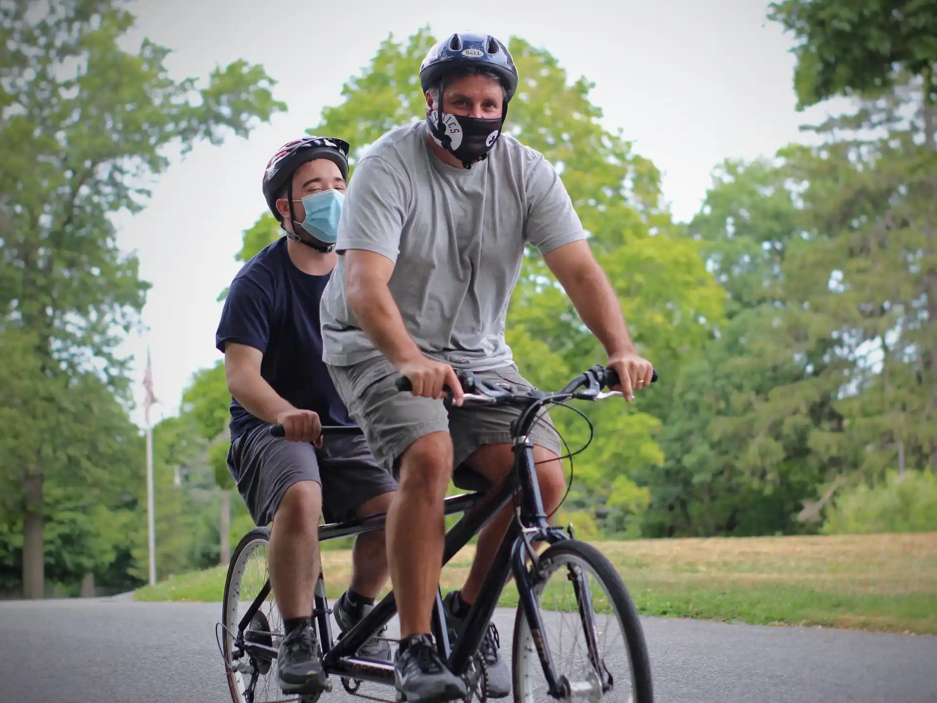 a man on a bicycle with a man in a mask on his face