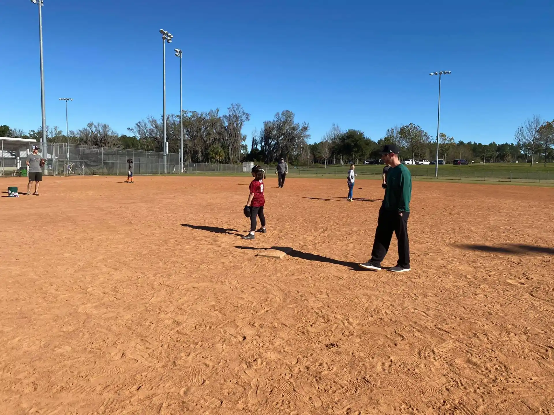 a person and a group of kids playing baseball