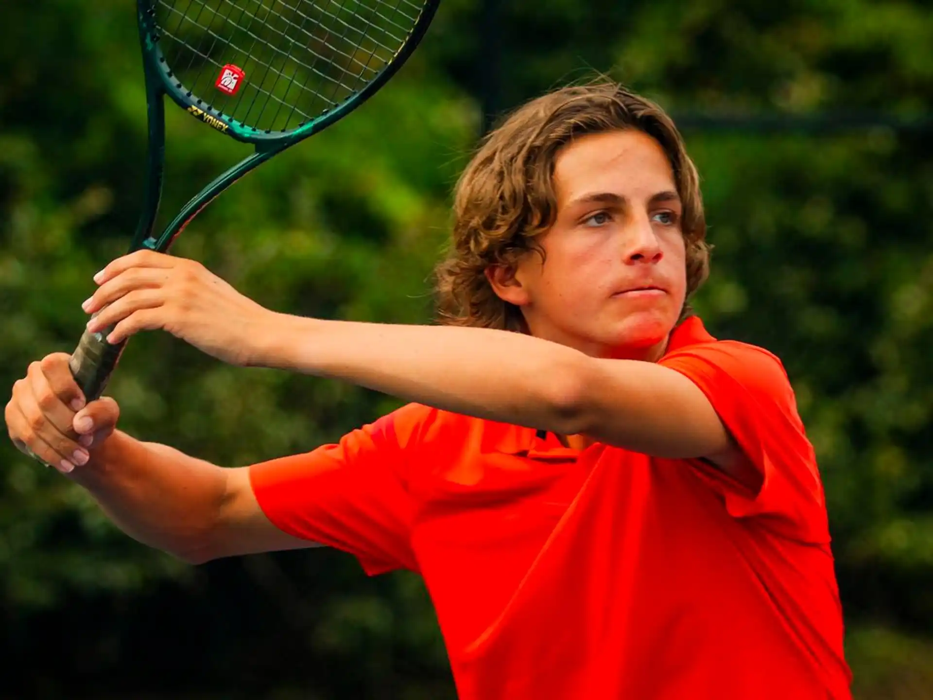 a young boy playing tennis