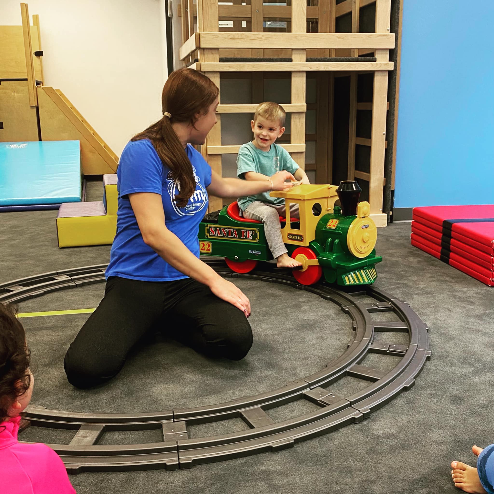 a person and a child playing on a toy train