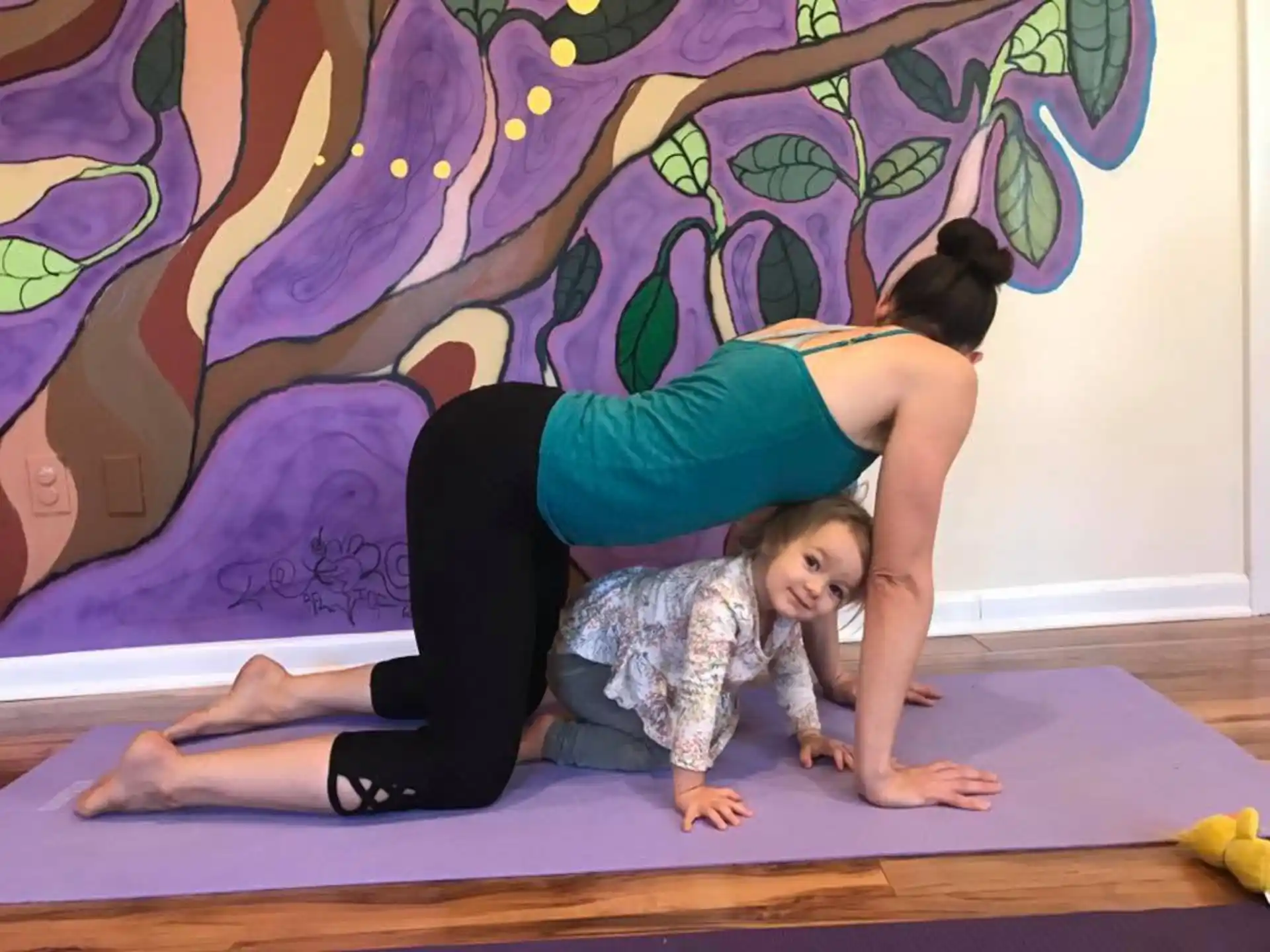 a woman and a child lying on a mat