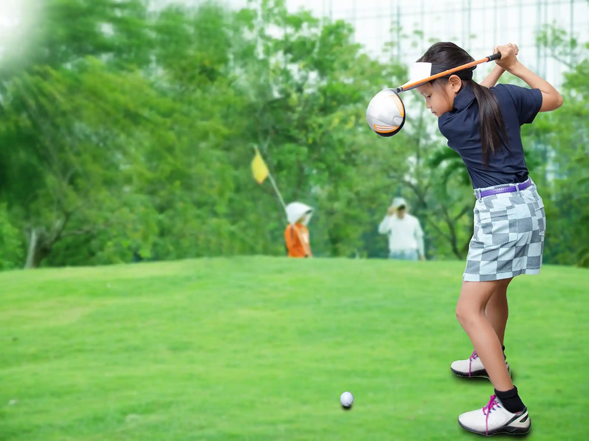a girl swinging a golf club
