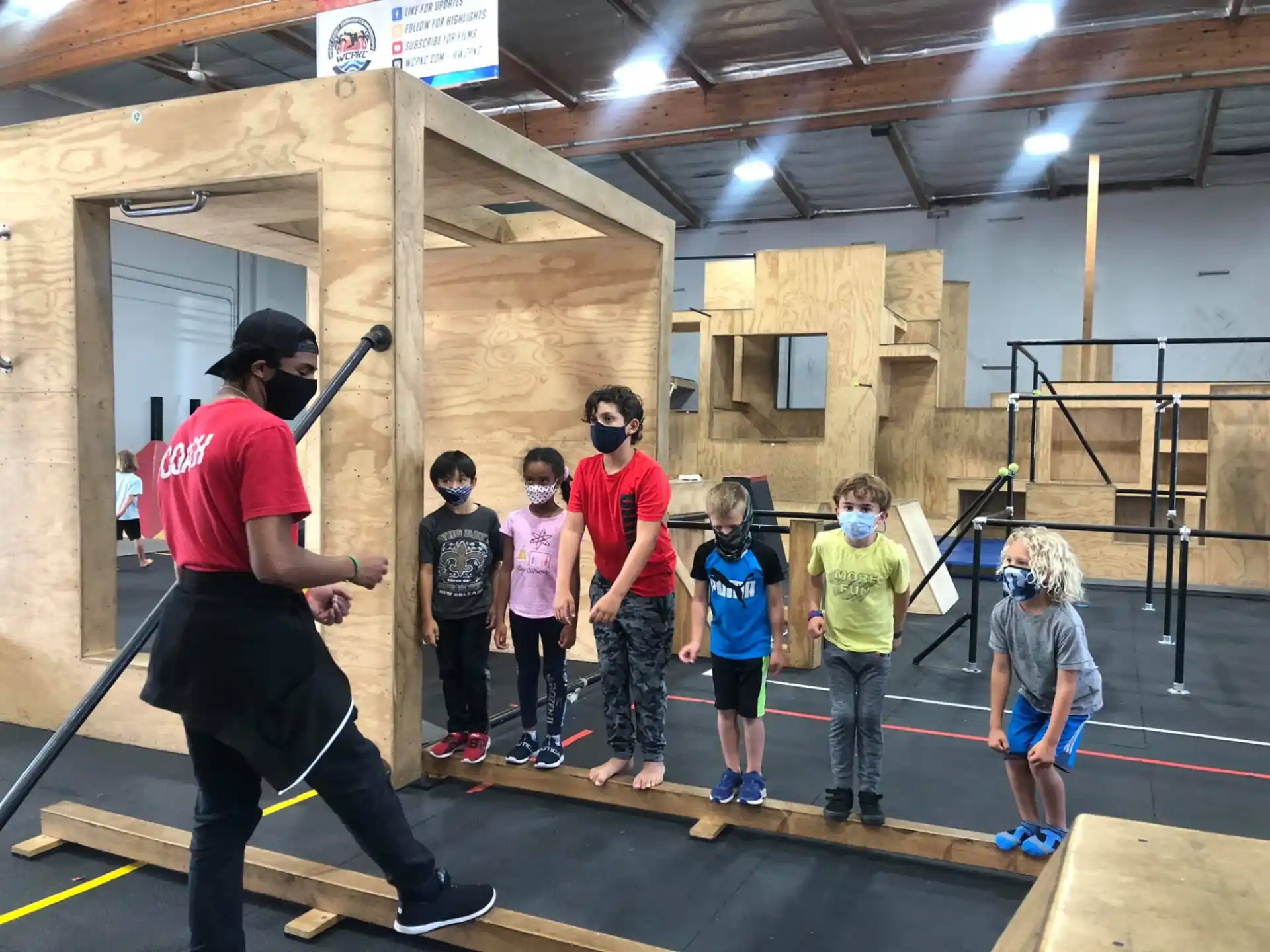 a man holding a sword in front of a group of kids