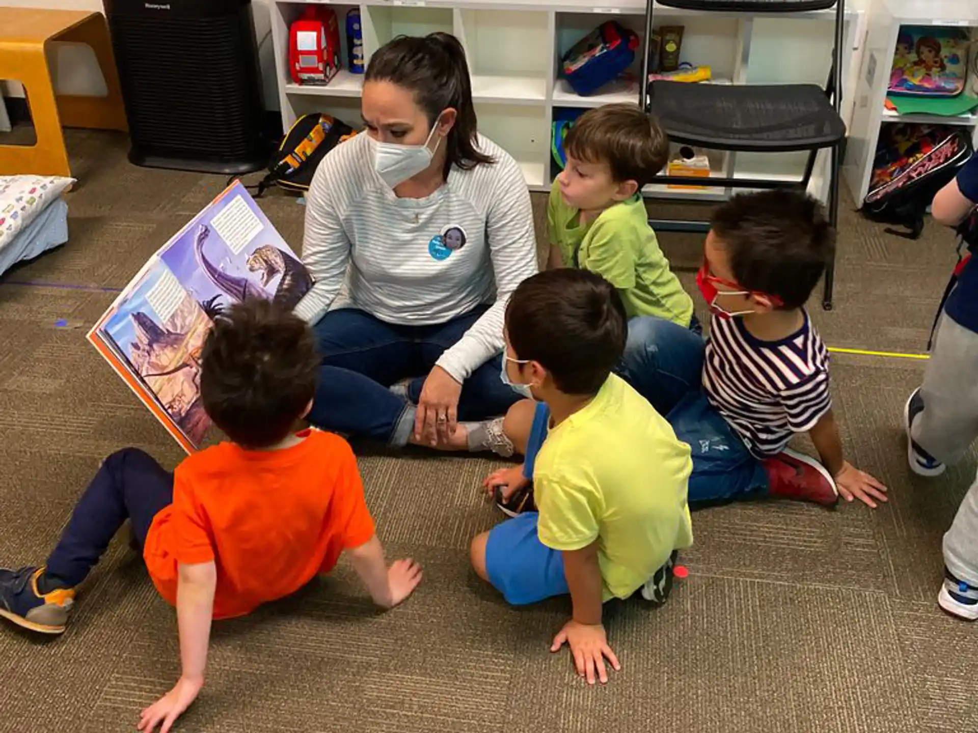 a person and several children sitting on the floor