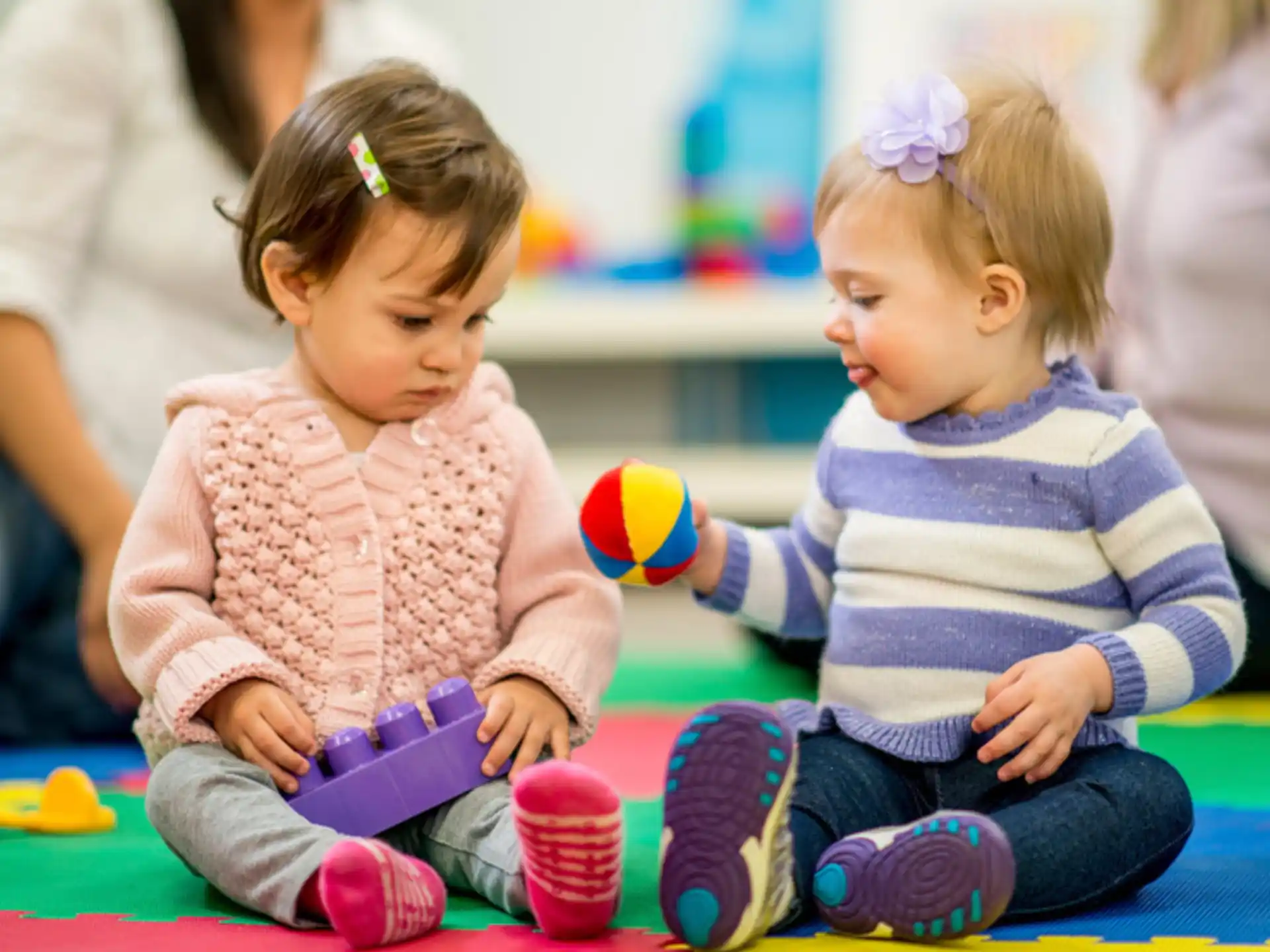 a couple of young girls sitting on the floor