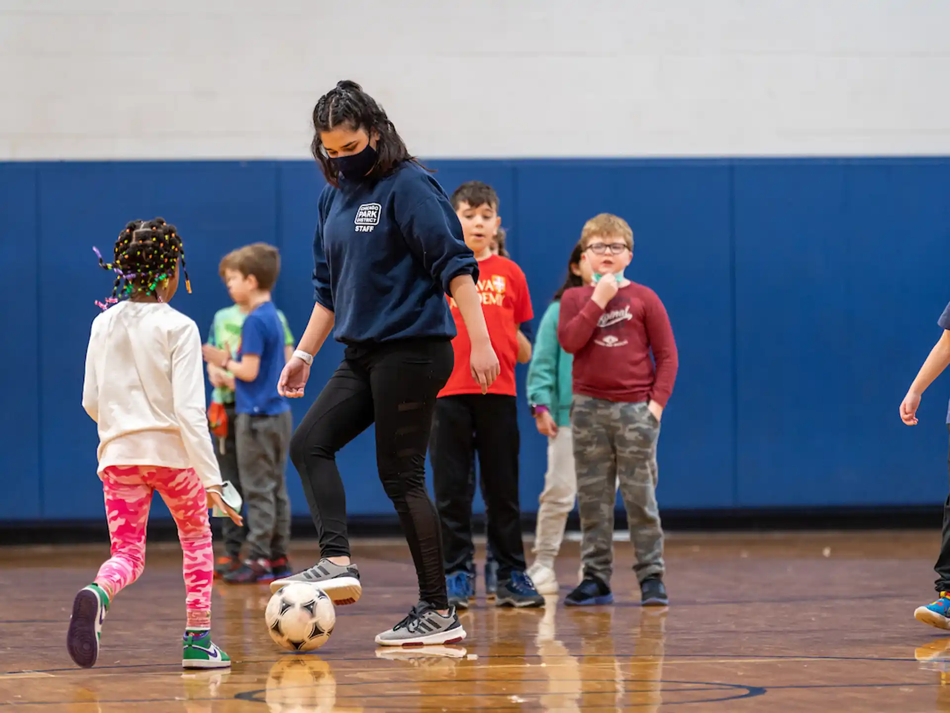 a person and kids playing football