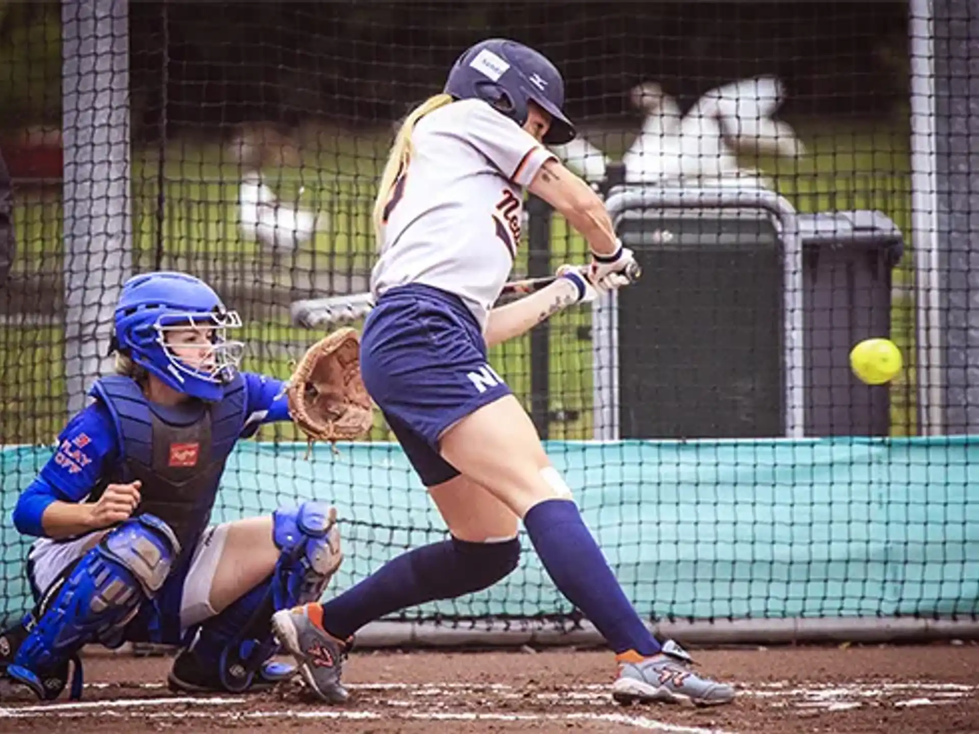 a person hitting a ball with the baseball bat