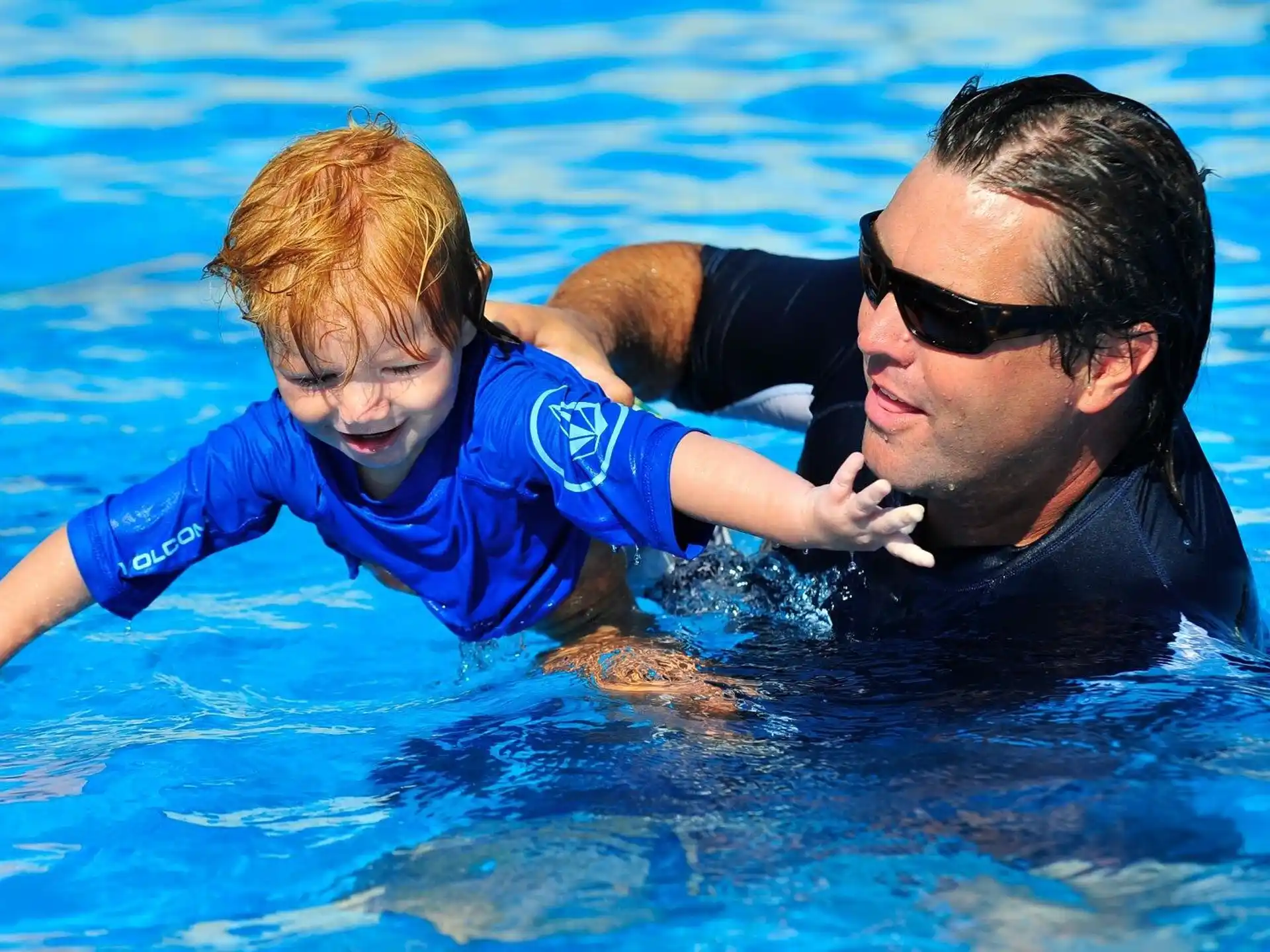 a man and a boy in a pool