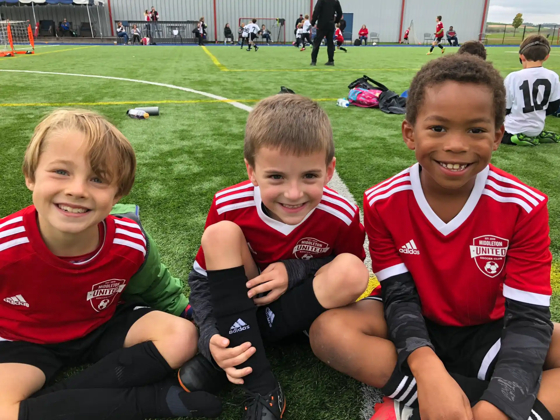 a group of boys sitting on a field