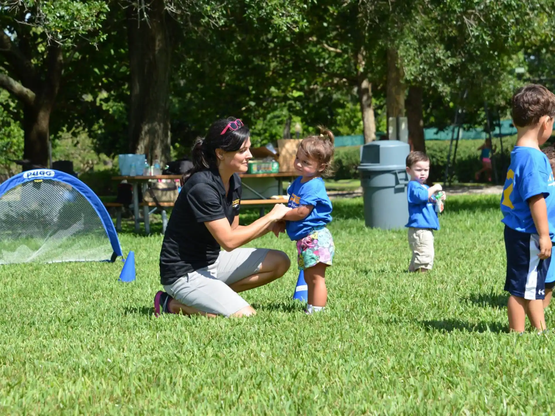 a person and kids playing with a net in a park