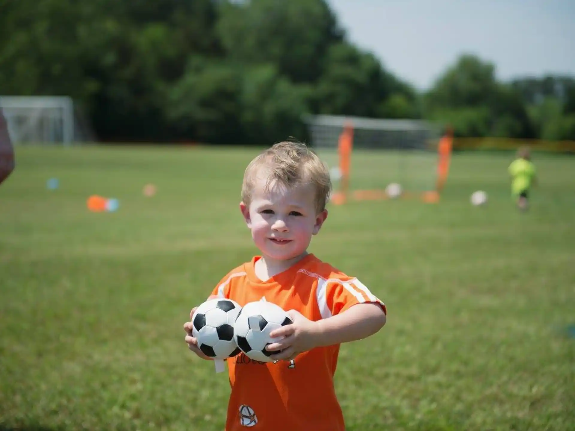 a boy holding a football ball