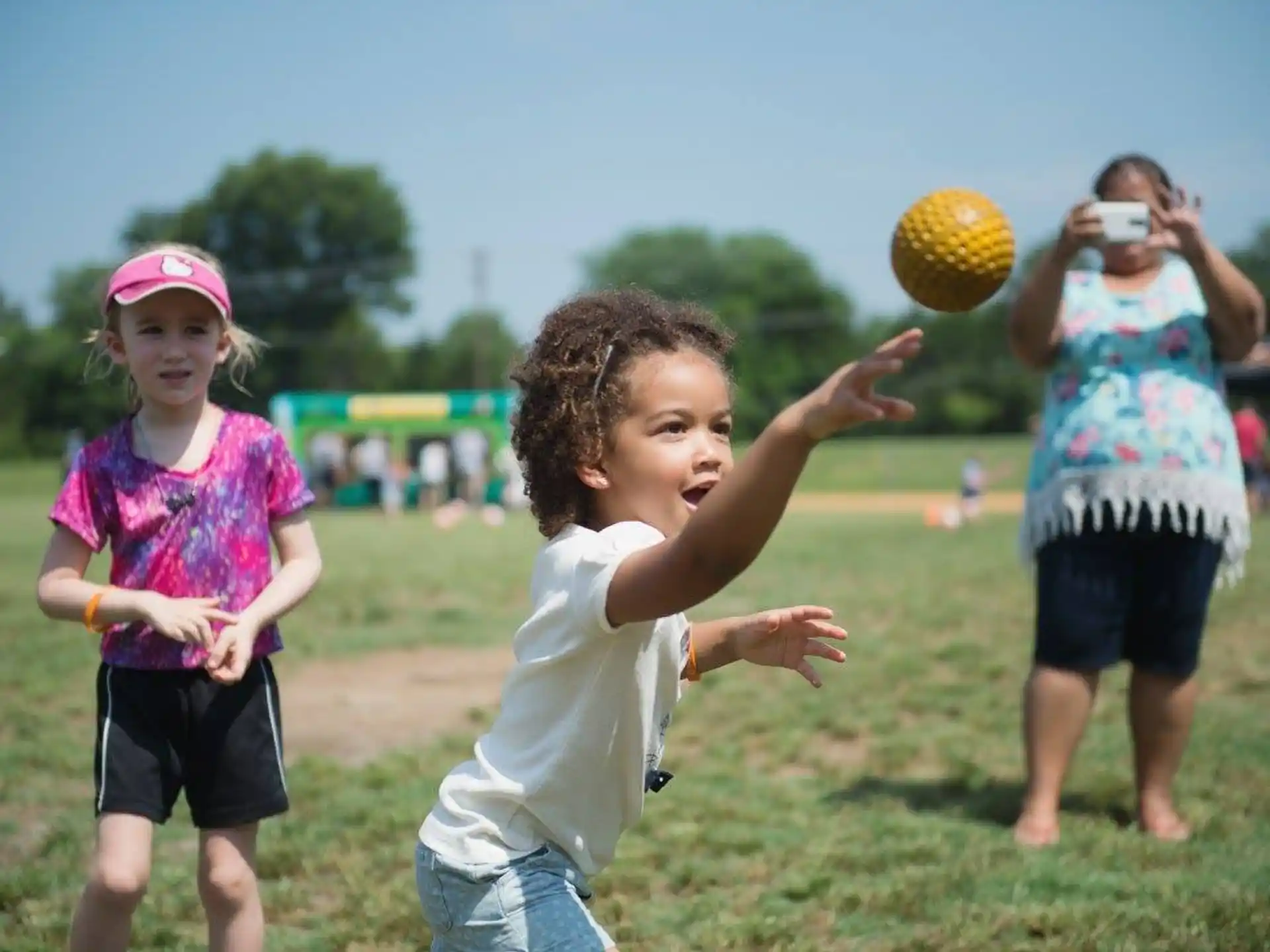 a group of children playing with a ball in a field