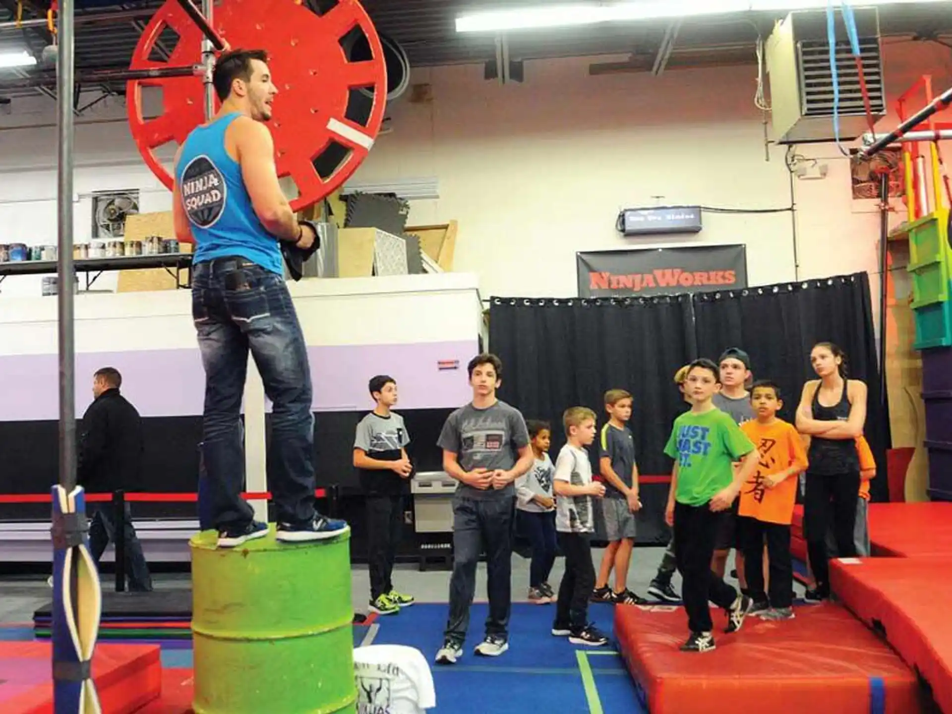 a person standing on a podium with a group of kids
