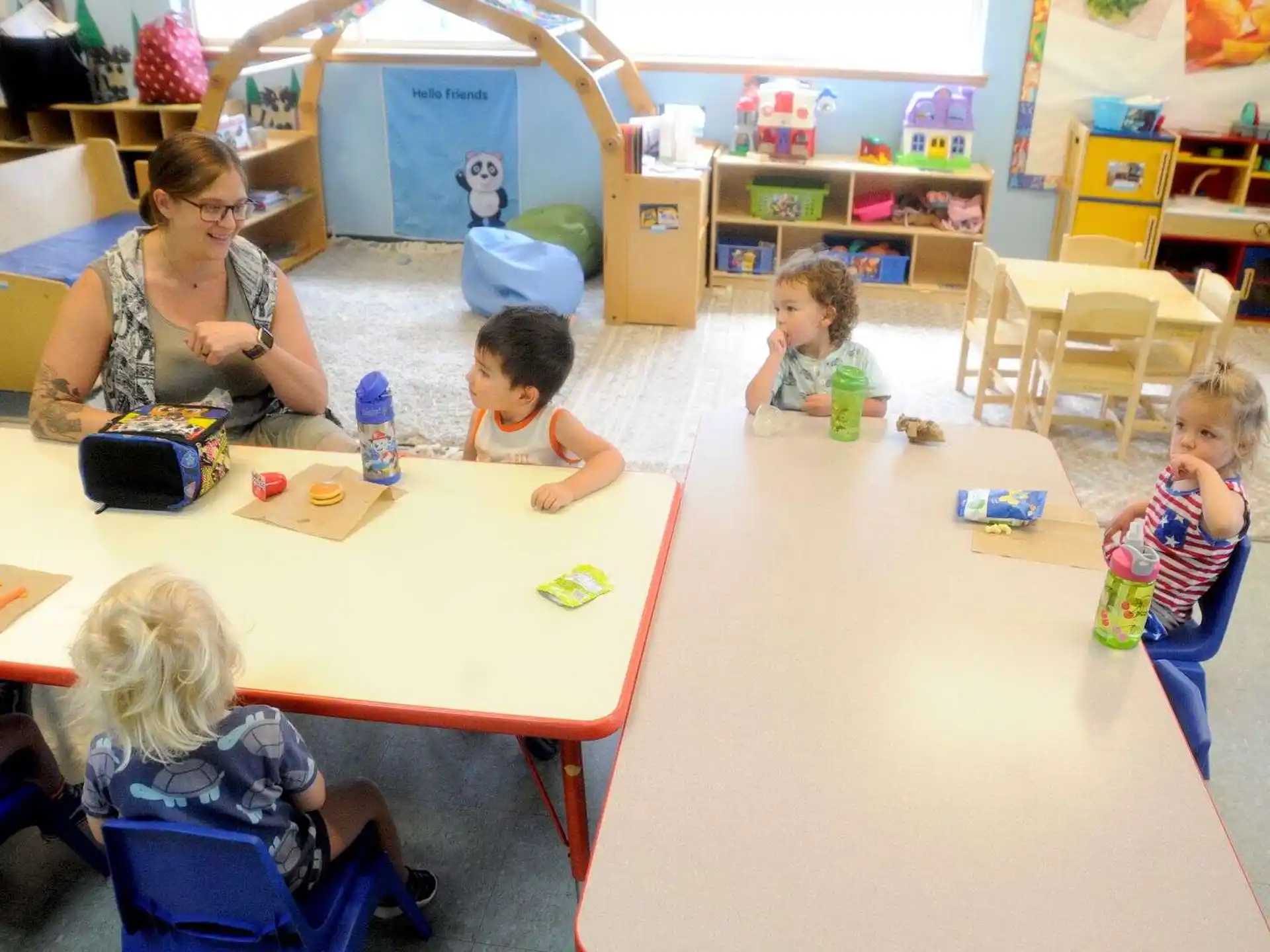 a person and several children sitting at a table