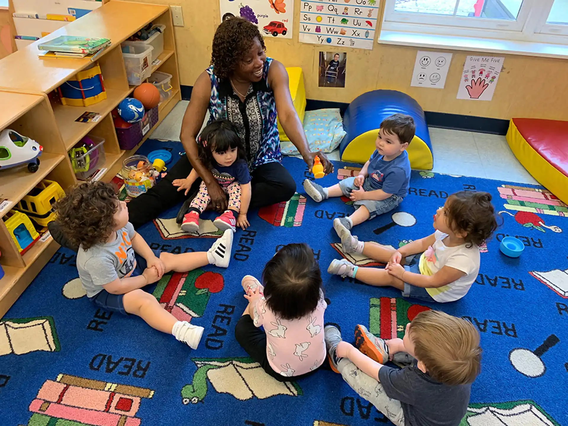 a person and several children sitting on the floor