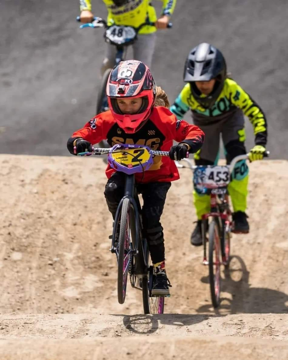a group of people riding bikes on a dirt track