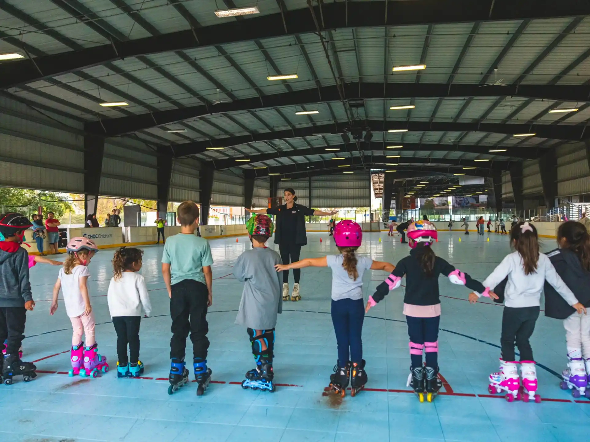 a group of kids wearing roller skates and helmets