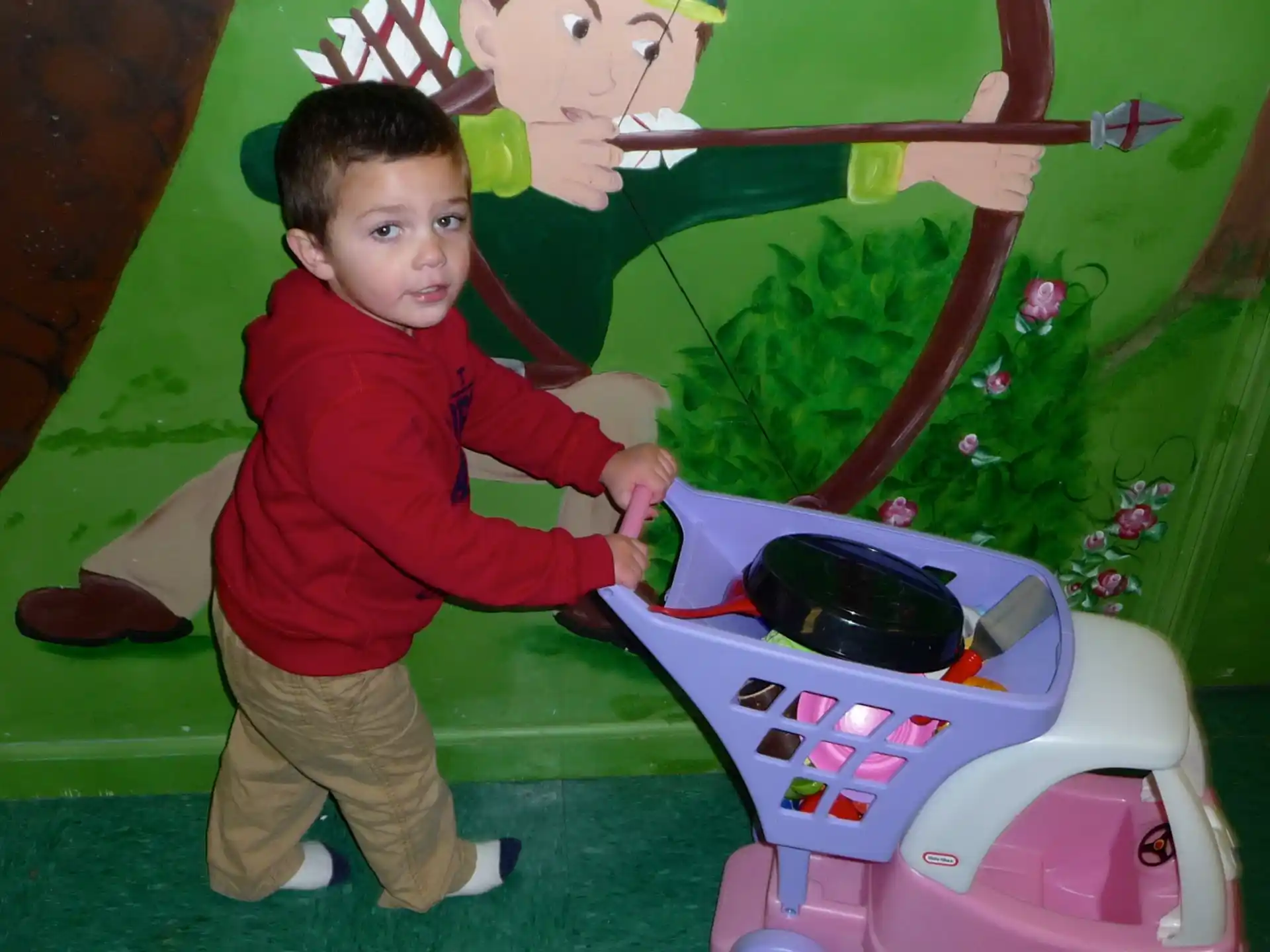 a boy standing next to a toy car