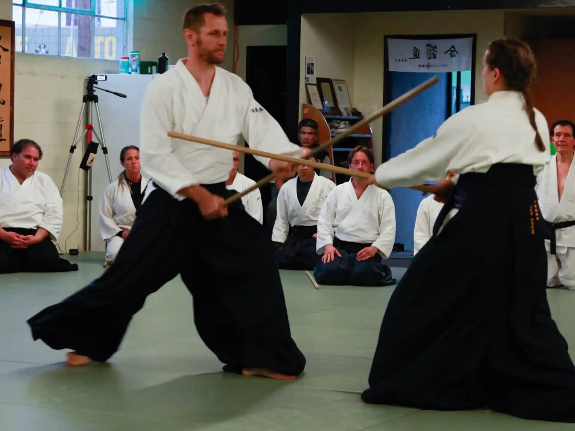 a man kicking another man in the face with a sword