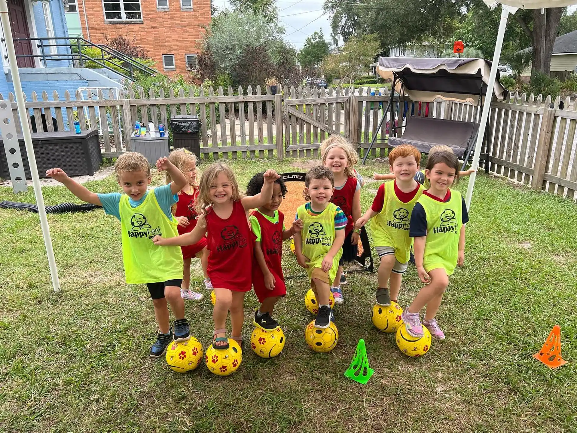 a group of kids posing for a picture with football balls
