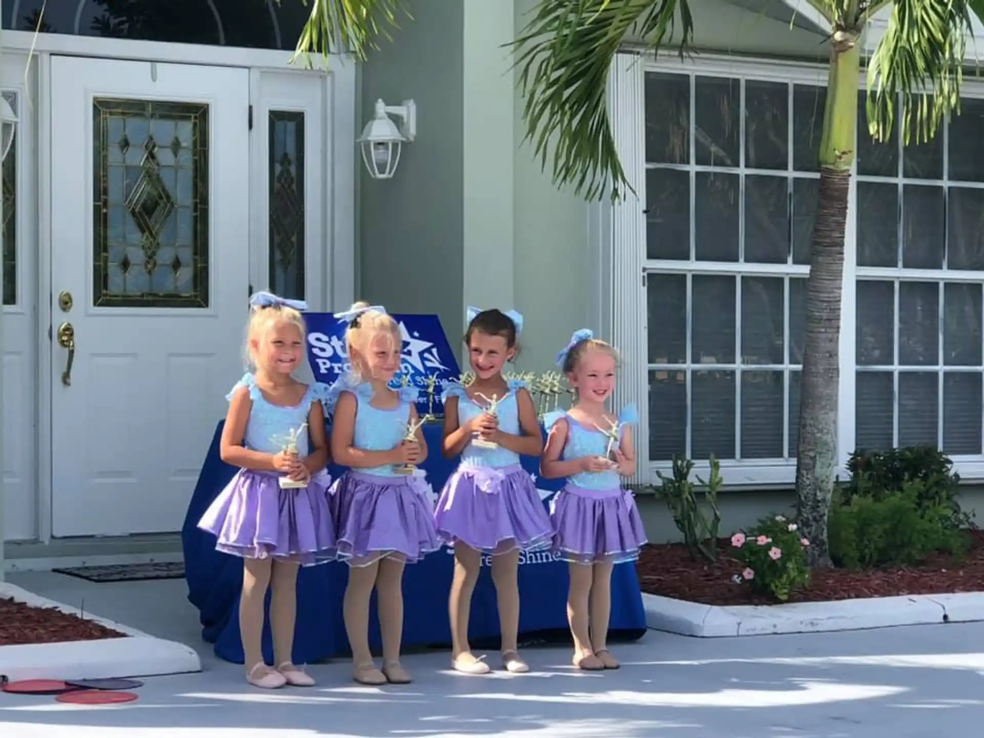 a group of girls in dresses posing for a photo