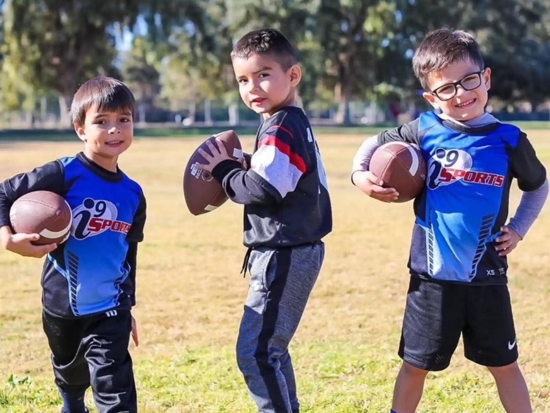 a group of boys holding footballs