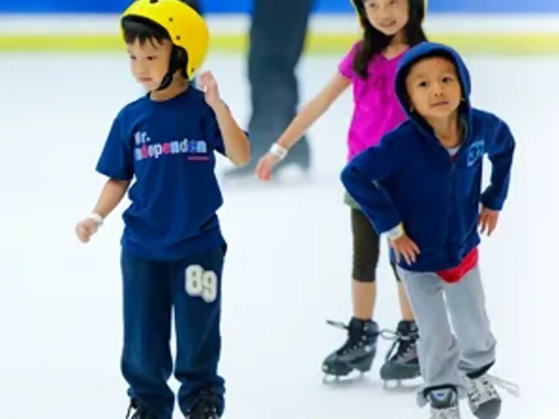 a group of kids wearing ice skates and helmets