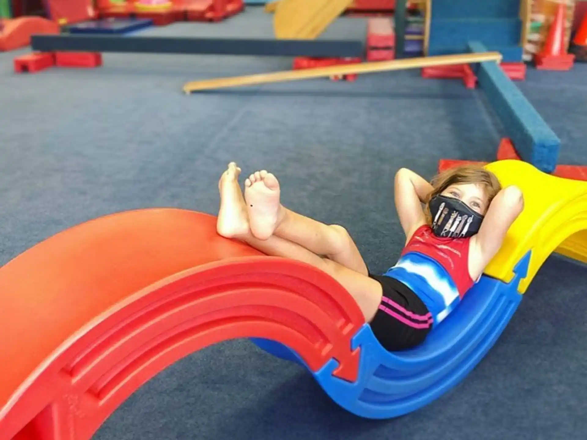 a person lying on a red and yellow tube on a blue surface