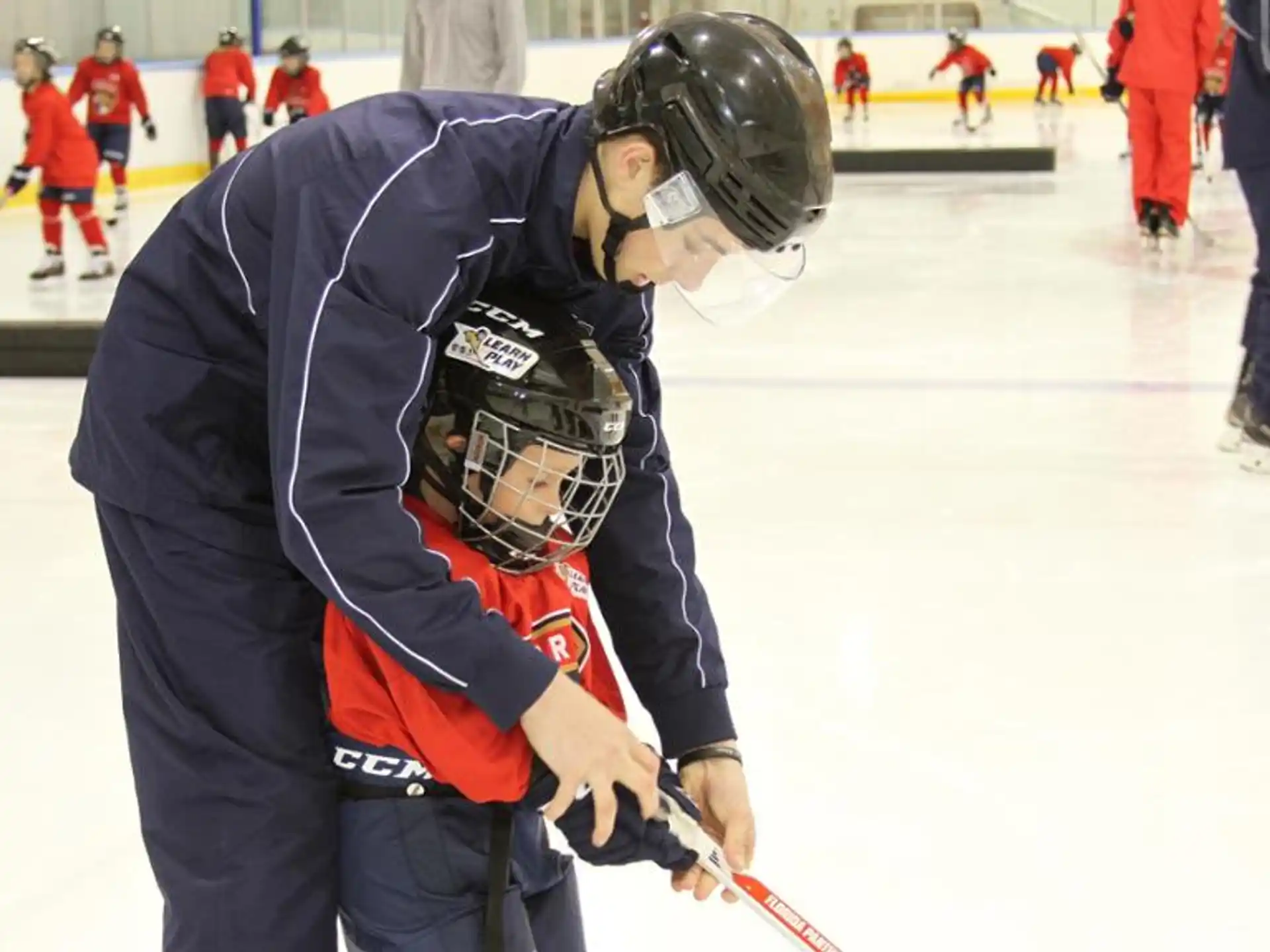 a person holding a hockey stick and another man holding a hockey stick