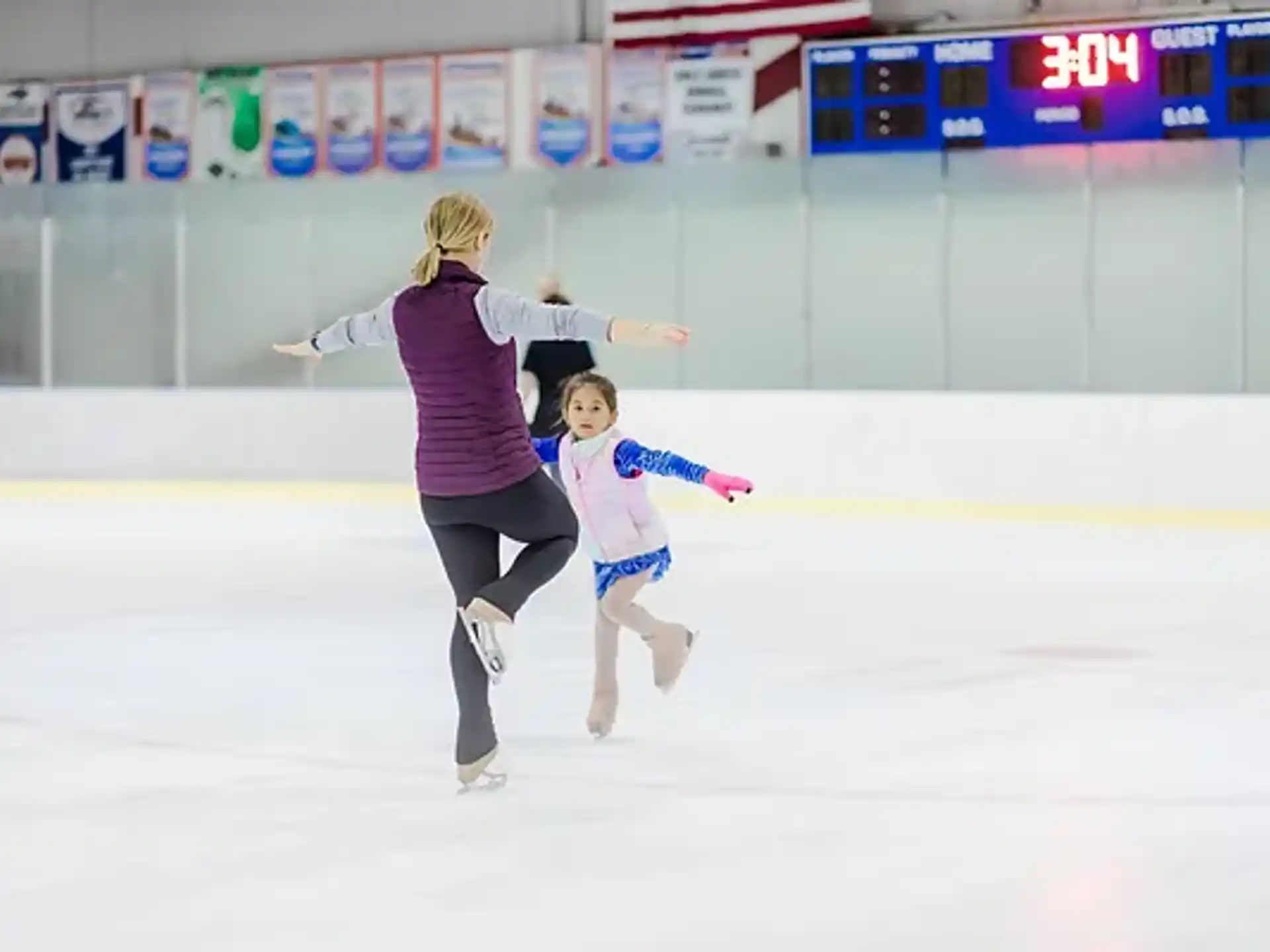 a woman and a girl ice skating
