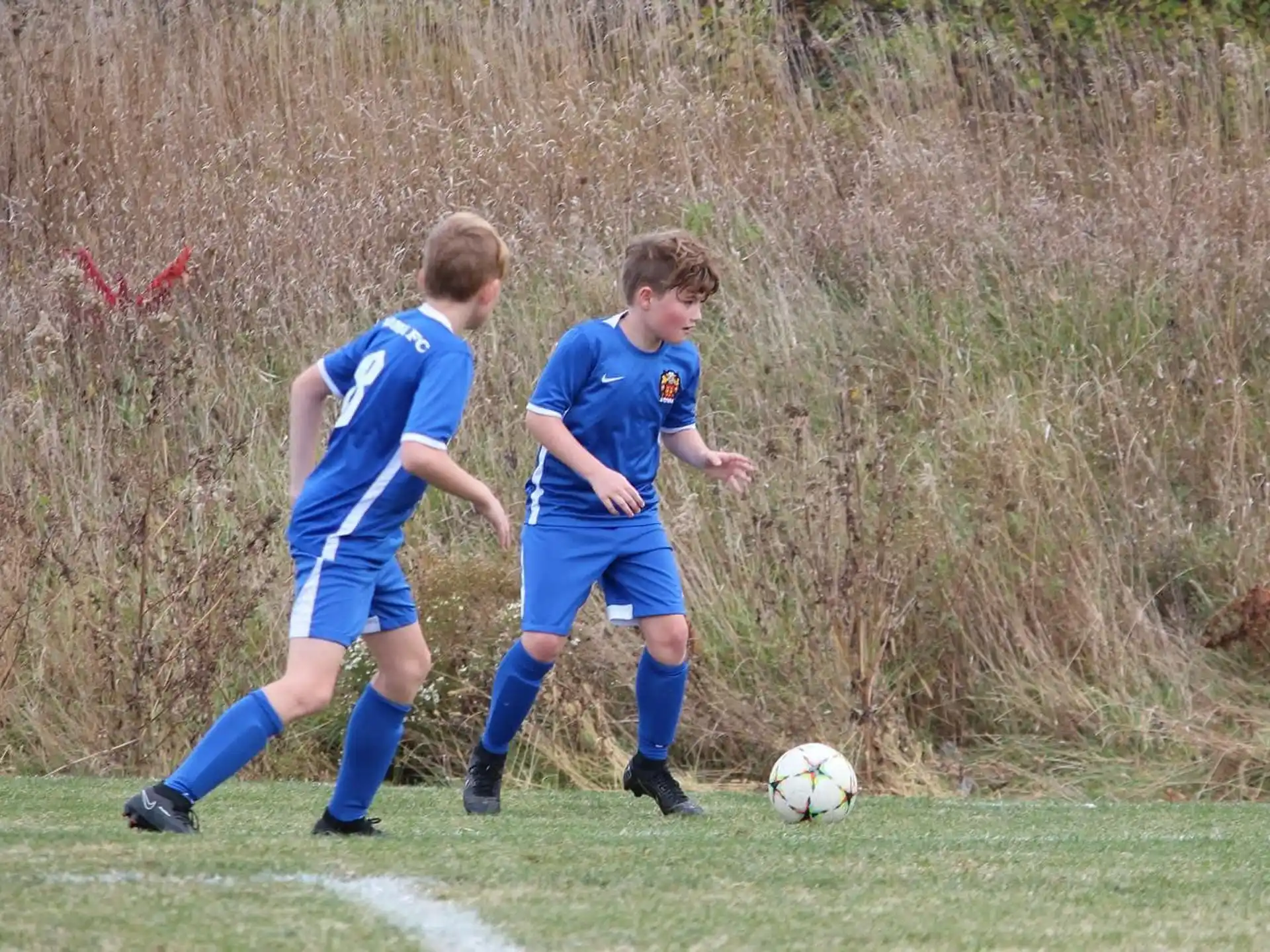a couple of boys compete over a football ball