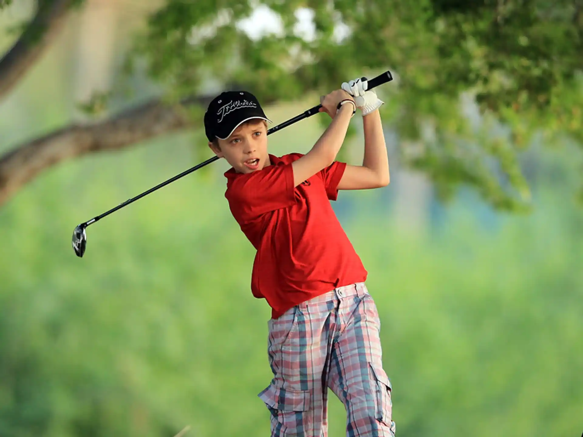 a boy swinging a golf club