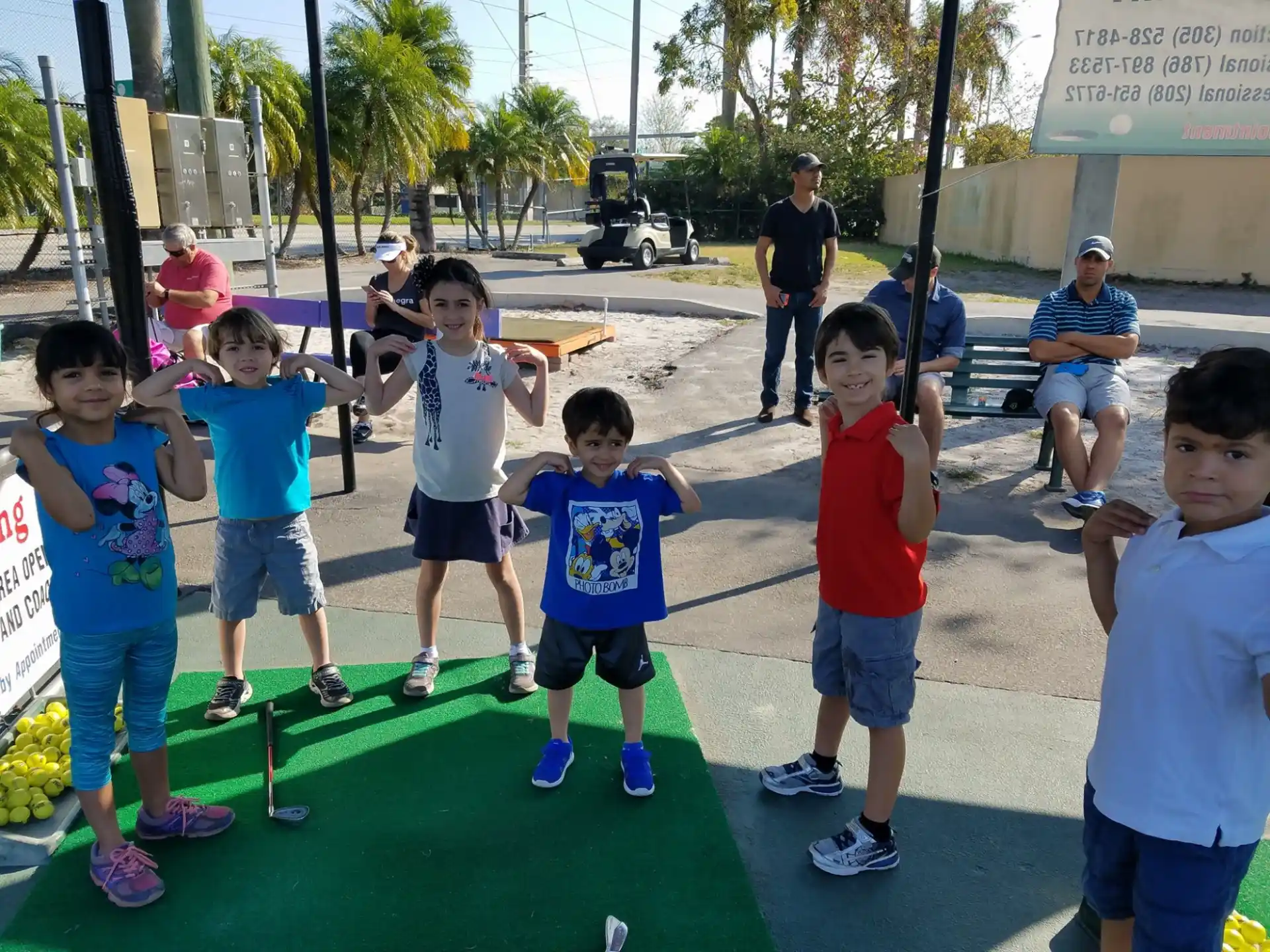 a group of children standing on a green mat