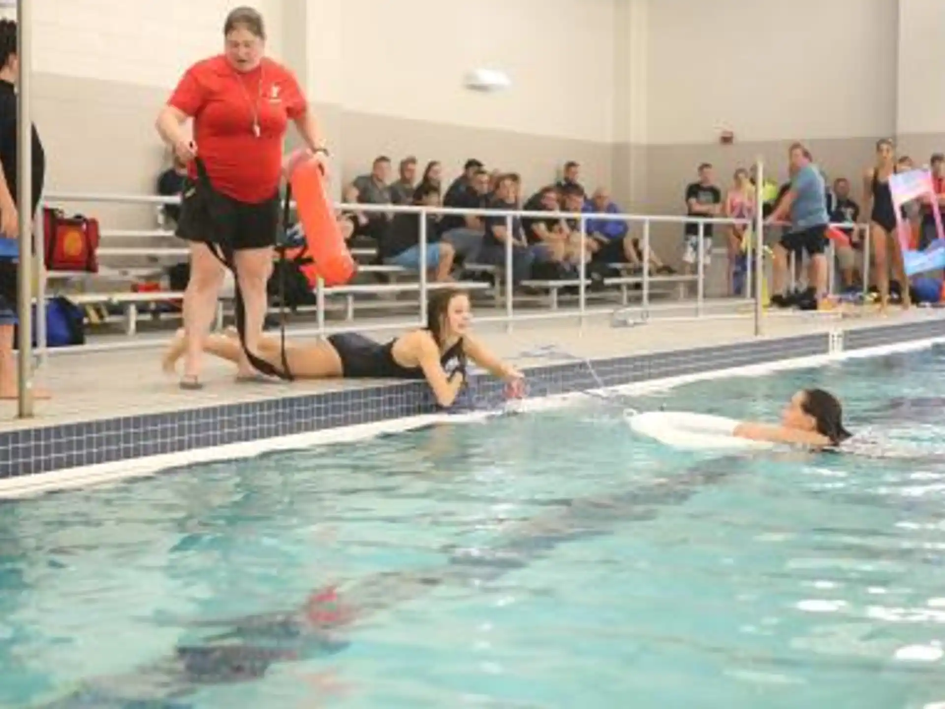 a woman in a pool with a man lying on her back