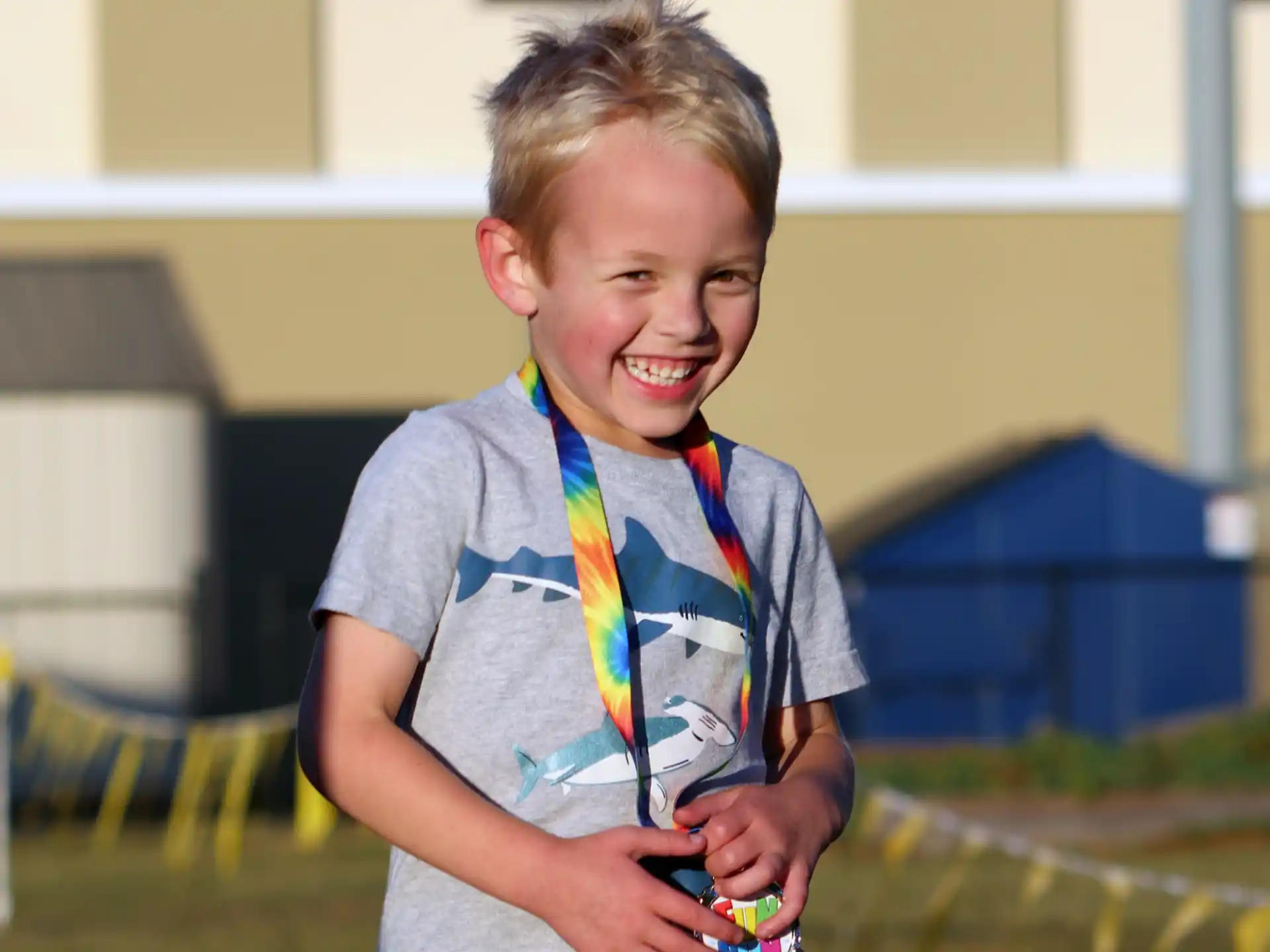 a boy smiling and holding a toy