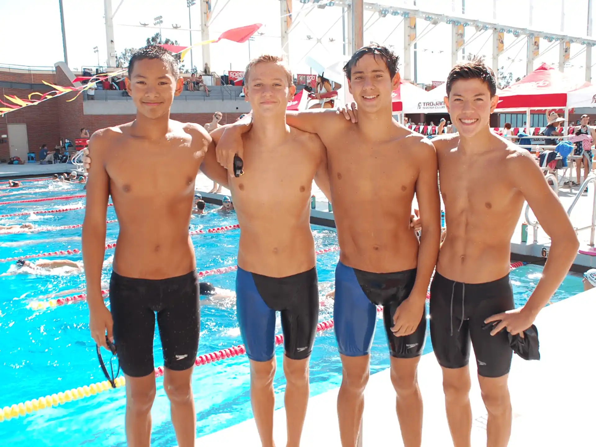 a group of men posing for a picture in front of a pool