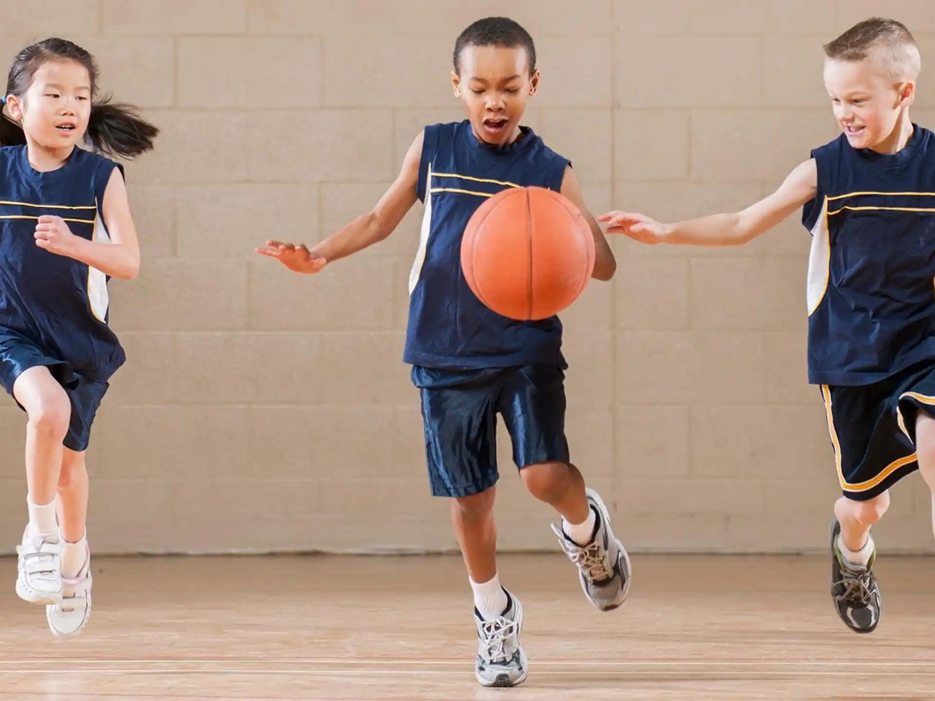 a group of kids playing basketball