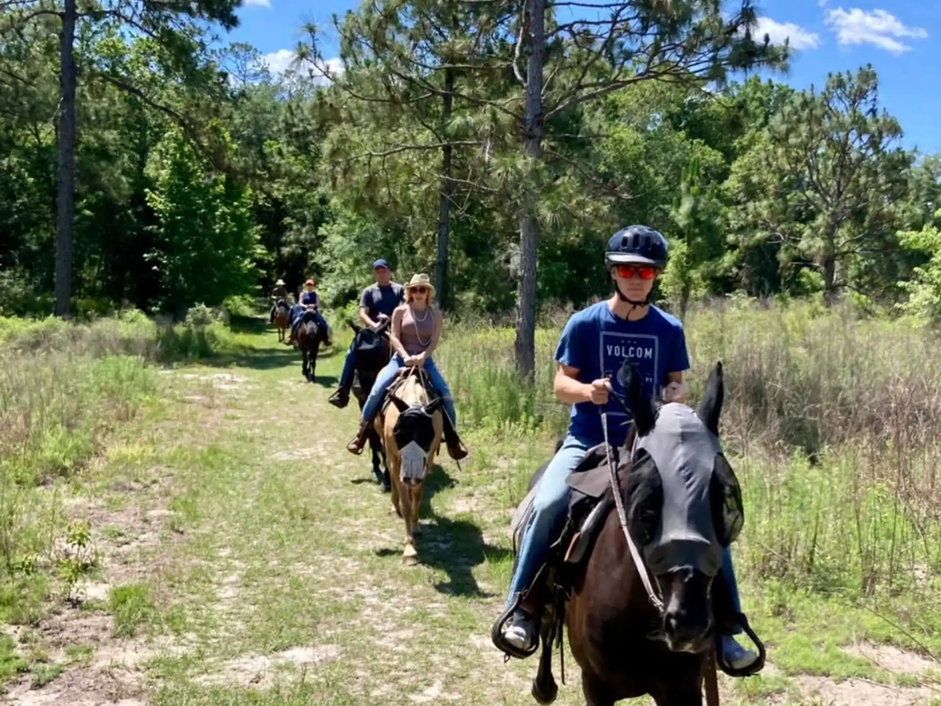 people riding horses on a trail