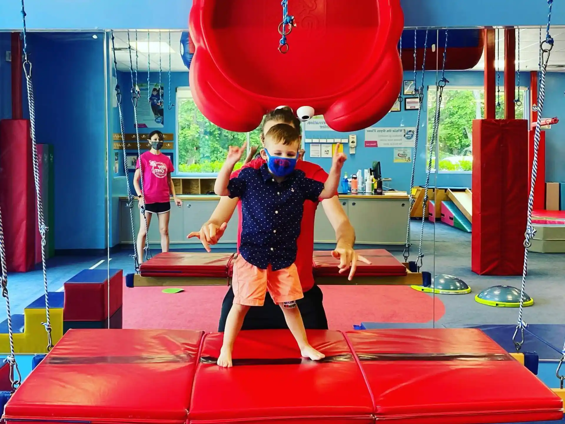 a boy standing on a red and blue slide