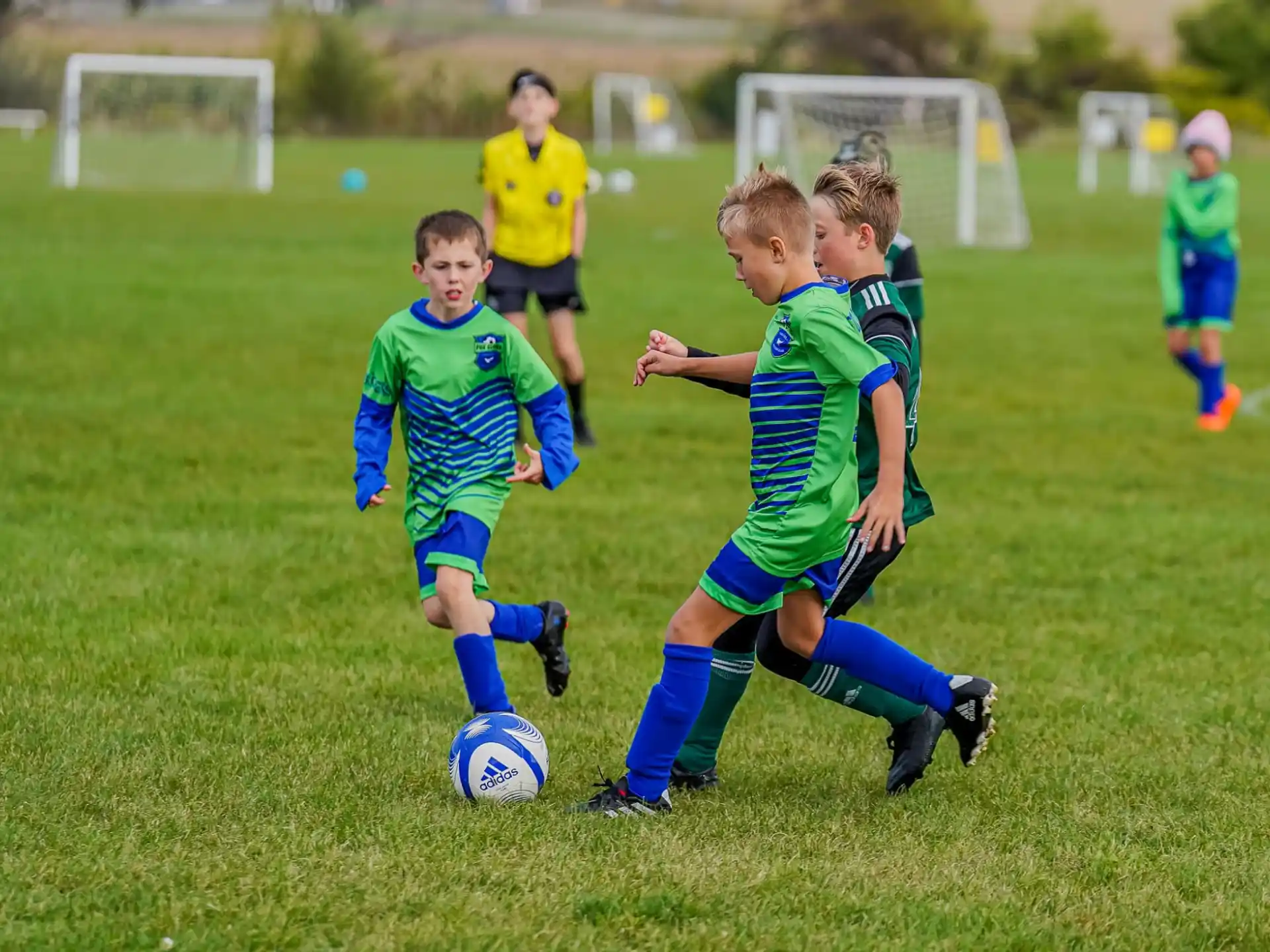 a group of kids compete over a football ball