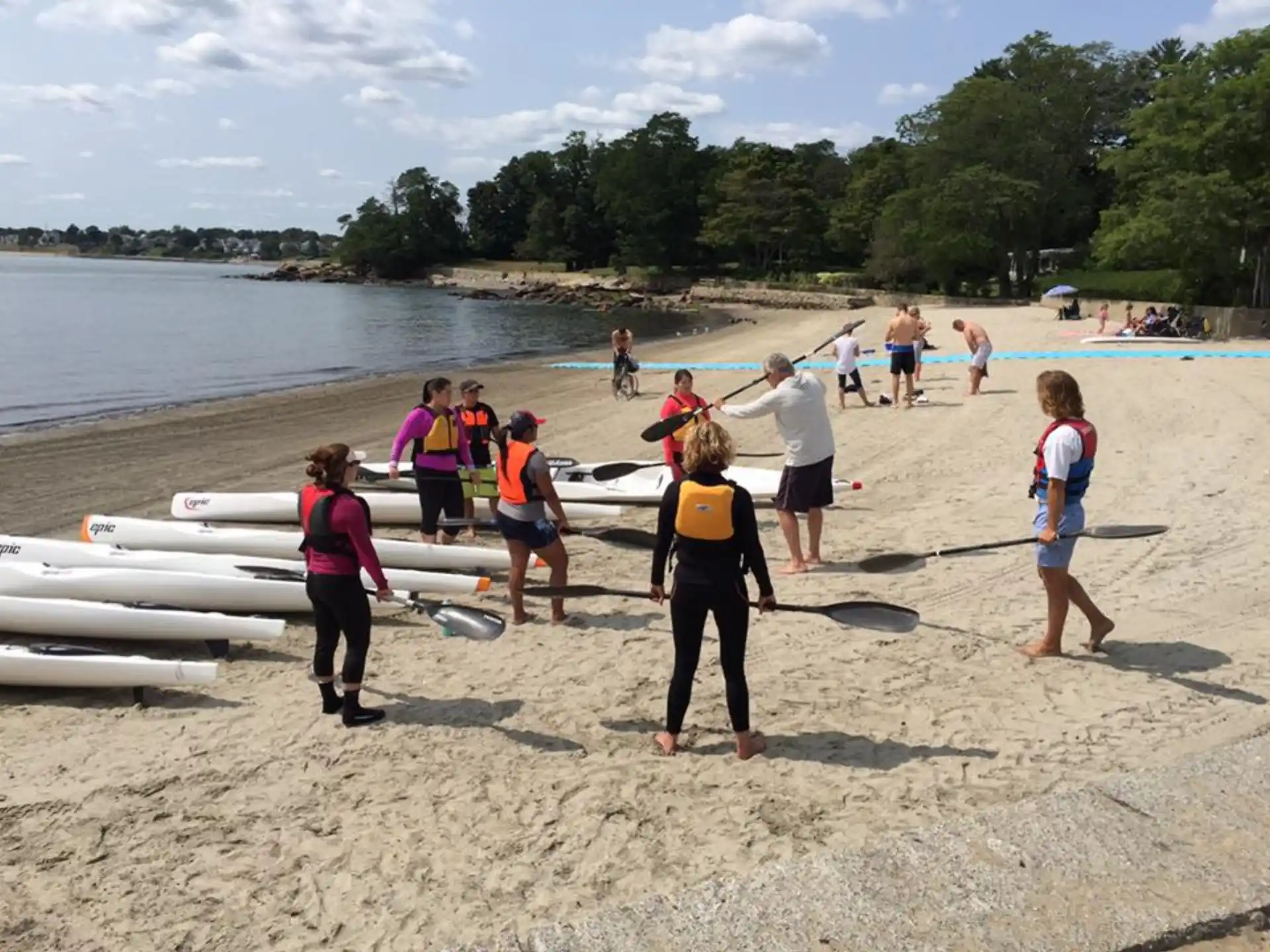 a group of people carrying surfboards on a beach