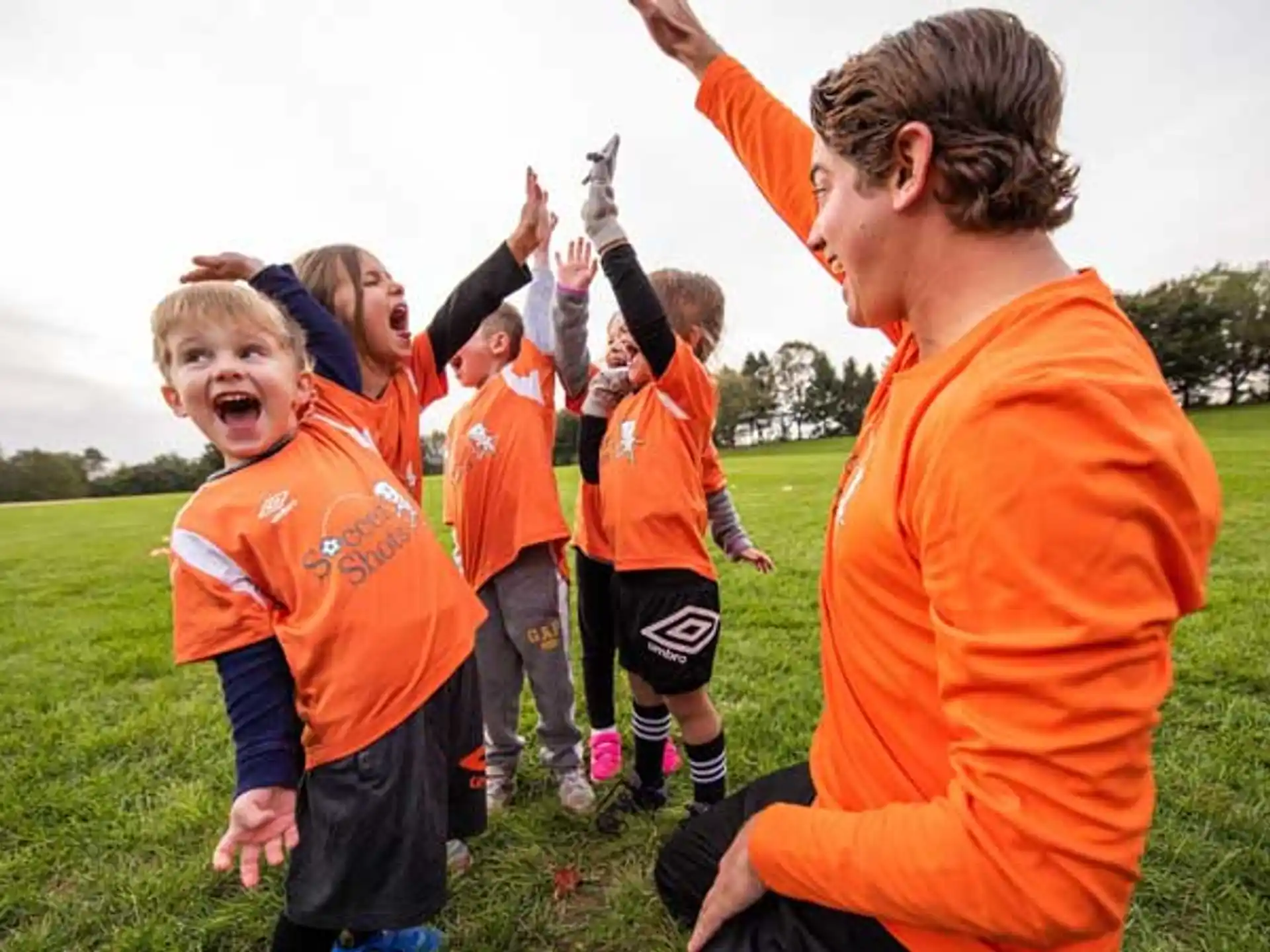 a group of kids in orange uniforms