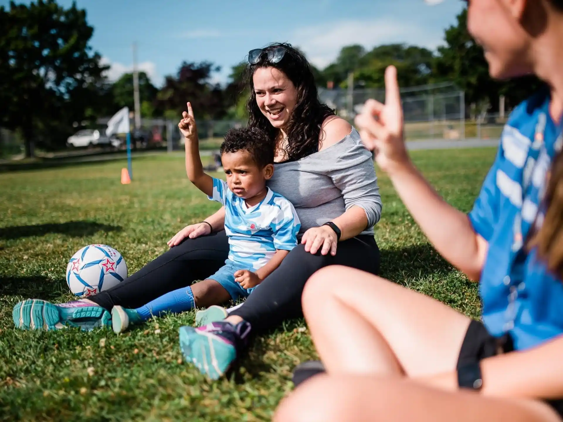 a person and a couple of children sitting on the grass