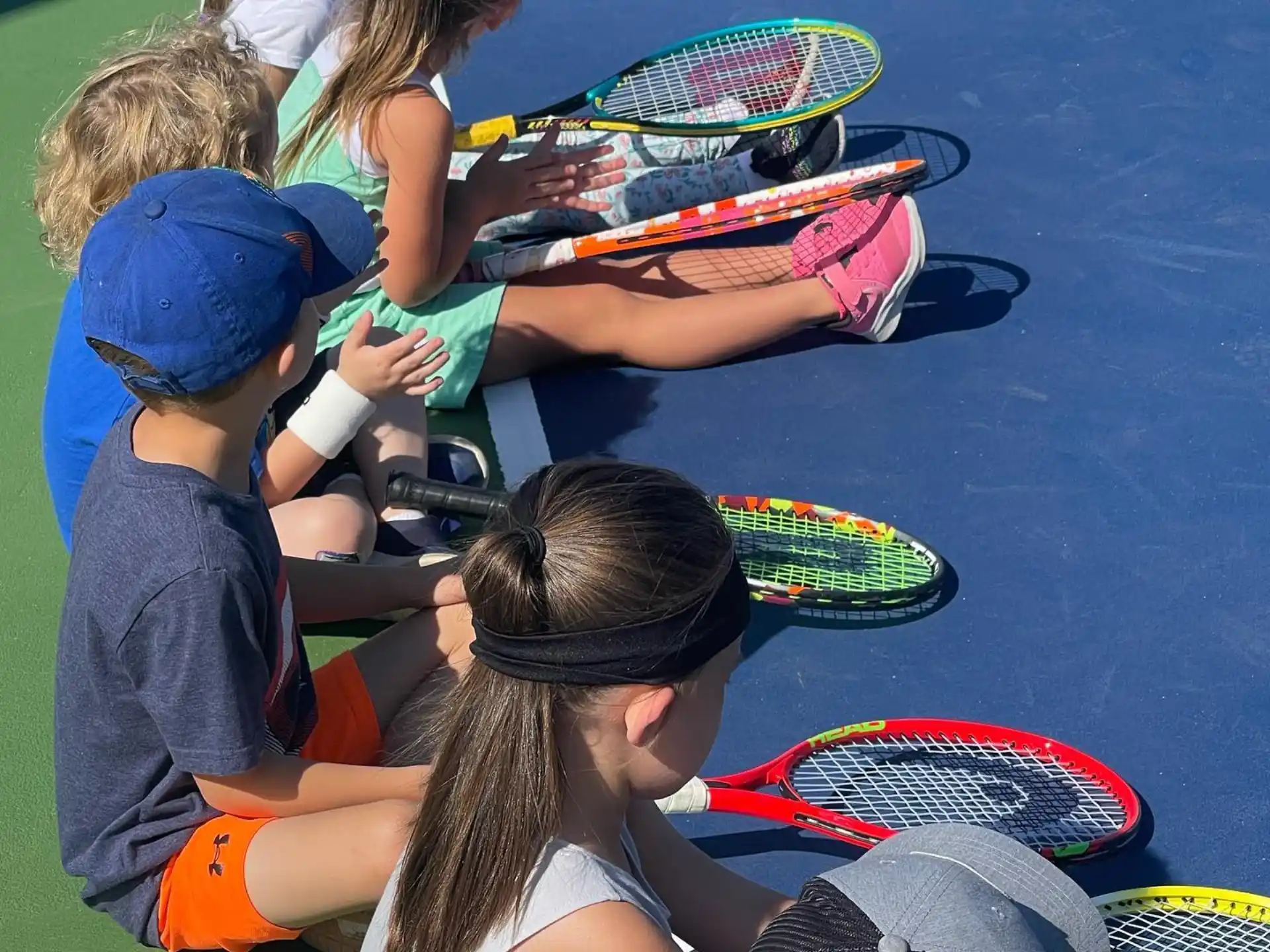 a group of kids playing with tennis rackets