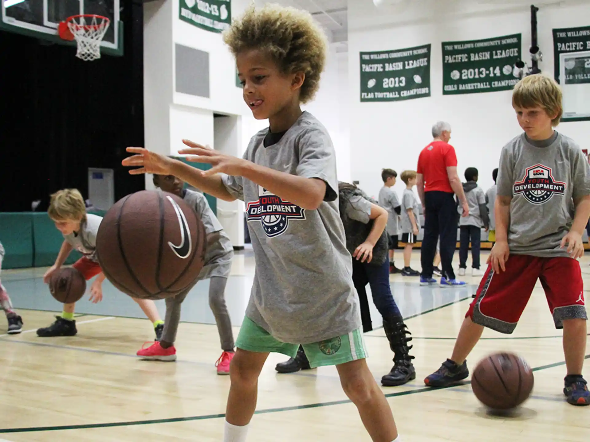 a group of kids playing basketball