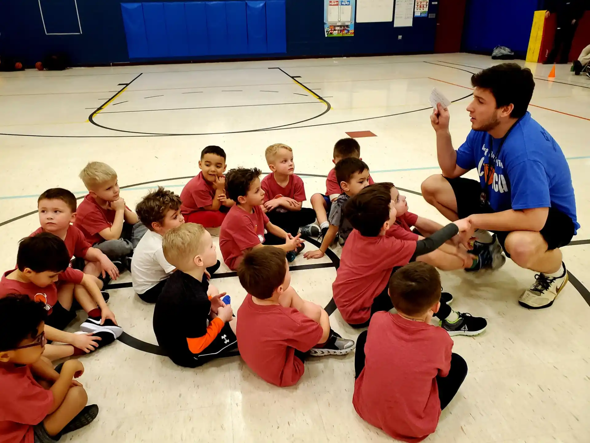 a person kneeling in front of a group of children